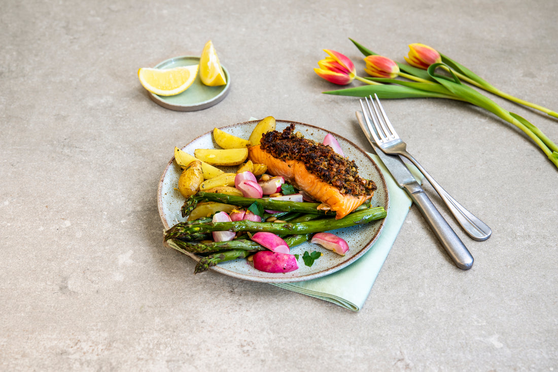 Lachsfilet mit Kräuterkruste auf grünem Spargel mit Radieschen und Kartoffeln